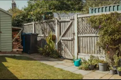 a fence with a wooden gate in a yard at Charming 2 Bedroom Cottage mid town on quiet road, sleeps 4 in Sudbury