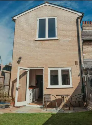 a house with a table and chairs in front of it at Charming 2 Bedroom Cottage mid town on quiet road, sleeps 4 in Sudbury
