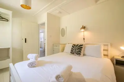a bedroom with a large white bed with towels on it at 6 Uplands in Thorpeness