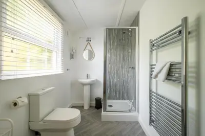 a bathroom with a shower and a toilet and a sink at 6 Uplands in Thorpeness
