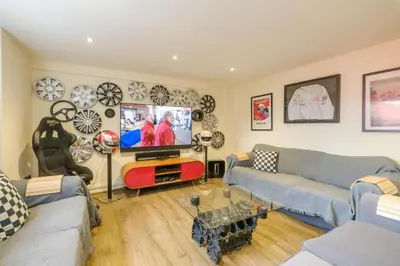 a living room with a couch and a flat screen tv at Mill House in Thorpeness