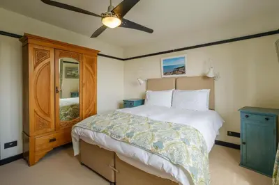 a bedroom with a bed and a ceiling fan at Mill House in Thorpeness