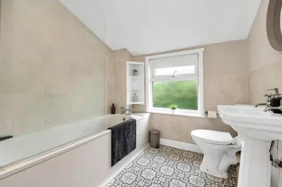a bathroom with a sink toilet and a window at Delightful 10 St Martins - 2 bed, 2 bathroom with parking available in Bury Saint Edmunds