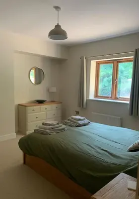 a bedroom with a bed with a dresser and a window at Tasburgh - Farthings in Norwich