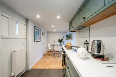 a kitchen with white cabinets and a counter top at 10 Hertford Place in Aldeburgh