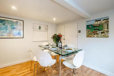 a dining room with a table and white chairs at 10 Hertford Place in Aldeburgh