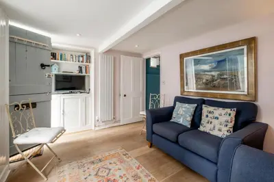 a living room with a blue couch and a chair at 10 Hertford Place in Aldeburgh