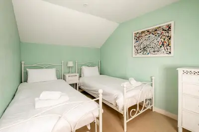 two beds in a room with green walls at 10 Hertford Place in Aldeburgh