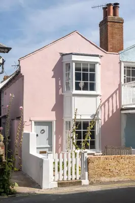 a pink house with a white fence at 10 Hertford Place in Aldeburgh