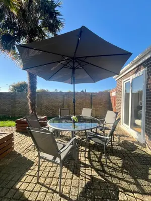 a table with chairs and an umbrella on a patio at The Palm Tree House in St Ives
