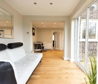 a living room with a white bed and a table at The Palm Tree House in St Ives