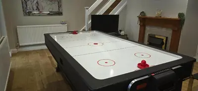 a ping pong table in a living room at The Palm Tree House in St Ives