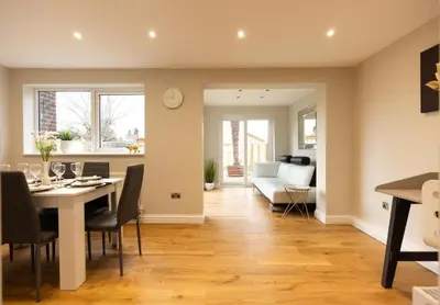a dining room and living room with a table and chairs at The Palm Tree House in St Ives