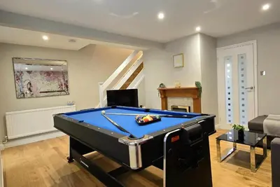a living room with a pool table in it at The Palm Tree House in St Ives
