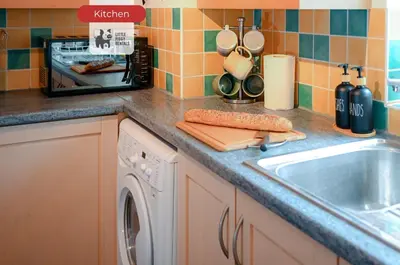 a kitchen counter with a sink and a dishwasher at Quiet Premium Stansted Apartment in Central Location with WiFi and Desk in Stansted Mountfitchet
