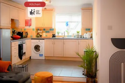 a kitchen with white cabinets and a washer and dryer at Quiet Premium Stansted Apartment in Central Location with WiFi and Desk in Stansted Mountfitchet