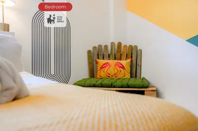 a bedroom with a wooden chair with a colorful pillow at Quiet Premium Stansted Apartment in Central Location with WiFi and Desk in Stansted Mountfitchet