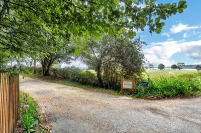 a sign on the side of a dirt road with trees at Stunning 2 Lodge Cottage retreat in Little Saxham