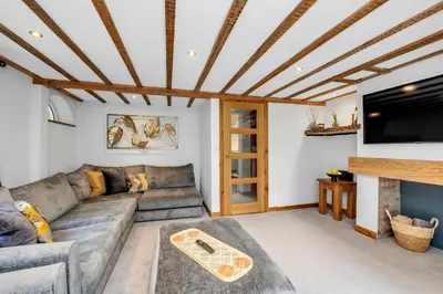 a living room with a couch and a flat screen tv at Stunning 2 Lodge Cottage retreat in Little Saxham