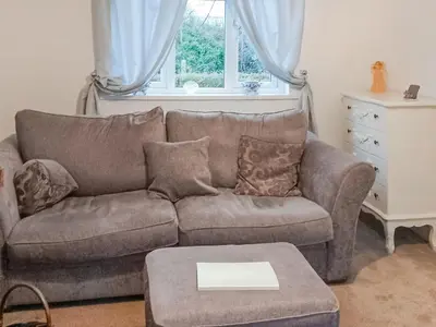a living room with a couch and a table at Ivy Rose Cottage in Ipswich