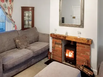 a living room with a couch and a fireplace at Ivy Rose Cottage in Ipswich