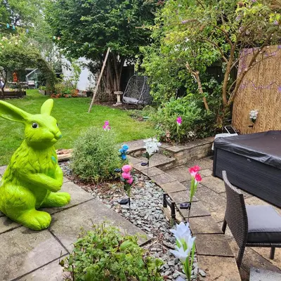 a green statue of a bunny sitting in a garden at Great Central self-contained flat in Cambridge