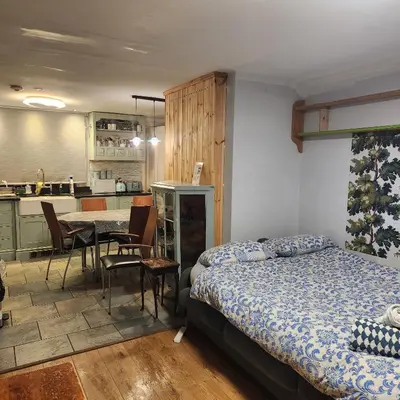 a bedroom with a bed and a table and a kitchen at Great Central self-contained flat in Cambridge