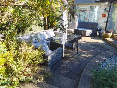 a patio with a blue couch and a table at Great Central self-contained flat in Cambridge