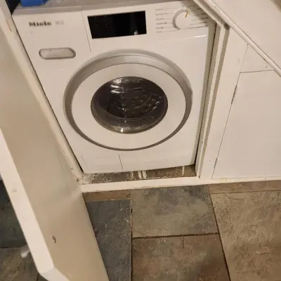 a washer and dryer sitting in a bathroom at Great Central self-contained flat in Cambridge