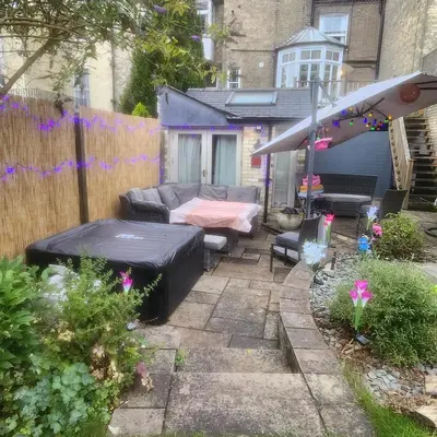 a patio with a couch and a table in a yard at Great Central self-contained flat in Cambridge