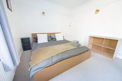 a bedroom with a large bed in a room at Charming Family-Friendly 3-Bedroom House with Parking & Spacious Garden in Milton