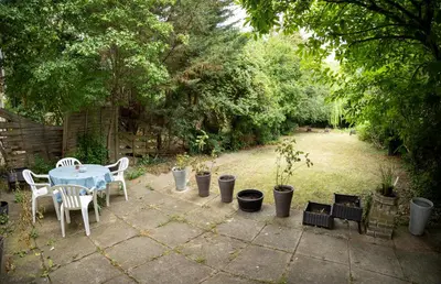 a patio with a table and chairs and plants at Charming Family-Friendly 3-Bedroom House with Parking & Spacious Garden in Milton