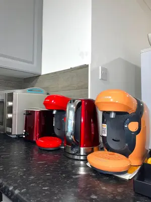 a kitchen counter with various appliances on a counter top at Penn Gardens Spacious king size room- 3 in Friern Barnet