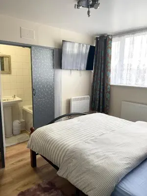 a bedroom with a bed and a bathroom at Penn Gardens Spacious 2 Beds - 1 in Friern Barnet