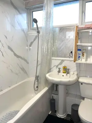 a white bathroom with a shower and a sink at Penn Gardens Spacious 2 Beds - 1 in Friern Barnet