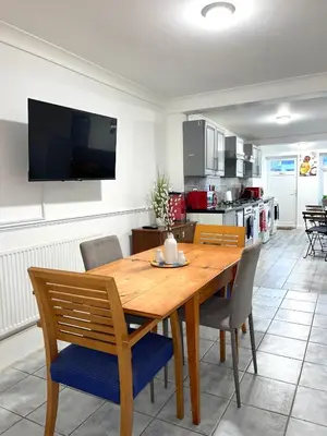 a dining room with a wooden table and chairs at Penn Gardens Spacious 2 Beds - 1 in Friern Barnet