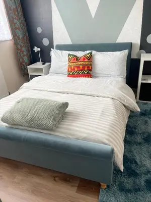 a bed with two pillows on it in a bedroom at Penn Gardens Spacious 2 Beds - 1 in Friern Barnet