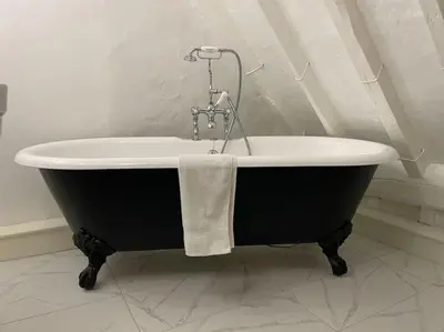 a bath tub with a towel on it in a bathroom at Old Cottage - English Countryside Retreat in Lindsell