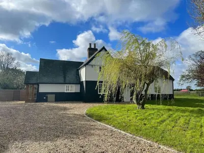 a white house with a tree in front of it at Mallards - English Countryside Retreat in Lindsell