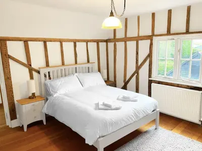 a bedroom with a white bed and a window at Mallards - English Countryside Retreat in Lindsell