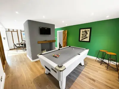 a pool table in a room with a green wall at Mallards - English Countryside Retreat in Lindsell