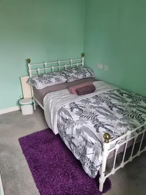 a bedroom with a bed and a purple rug at The Pringle Inn in Great Baddow