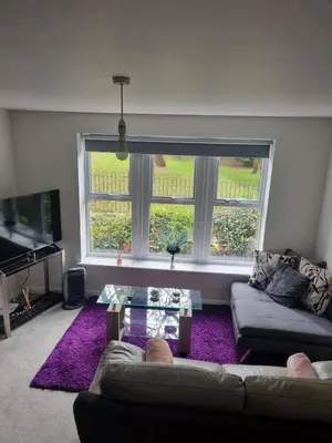 a living room with a couch and a large window at The Pringle Inn in Great Baddow
