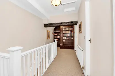 a hallway of a home with white walls and a staircase at Charming cottage in the centre of town in Bury Saint Edmunds