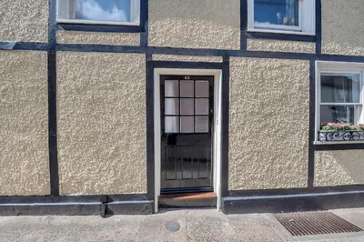 a door in the side of a building with two windows at Charming cottage in the centre of town in Bury Saint Edmunds