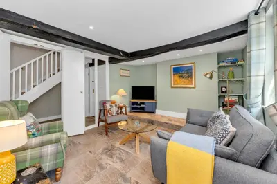 a living room with a couch and a tv at Charming cottage in the centre of town in Bury Saint Edmunds
