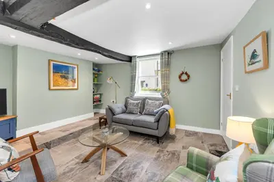 a living room with a couch and a table at Charming cottage in the centre of town in Bury Saint Edmunds