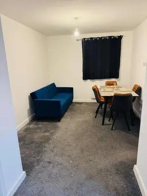 a living room with a blue couch and a table at Canvey Stay Entire Flat in Canvey Island