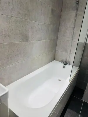 a white bath tub in a bathroom with a shower at Canvey Stay Entire Flat in Canvey Island
