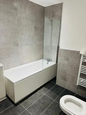 a bathroom with a white tub and a toilet at Canvey Stay Entire Flat in Canvey Island